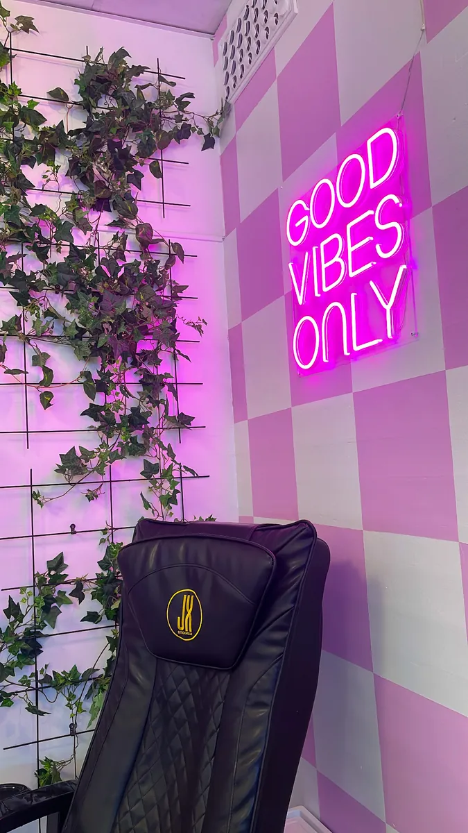 "Good vibes only"-neon mot rutig vägg