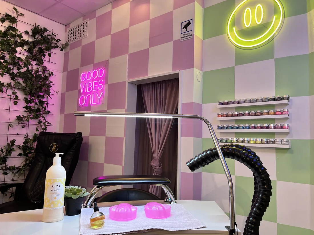 Neonsmiley och rutig vägg i Polish Nailbars studio i Göteborg.
